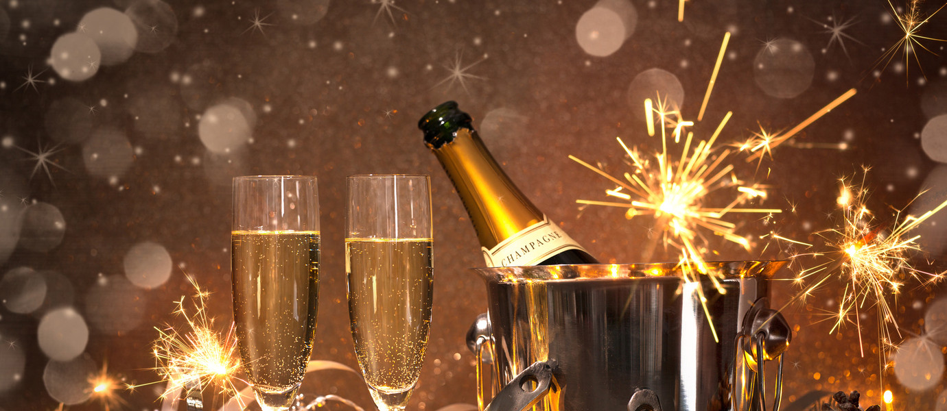 New Years Eve celebration background with pair of flutes and bottle of champagne in  bucket  and a horseshoe as lucky charm